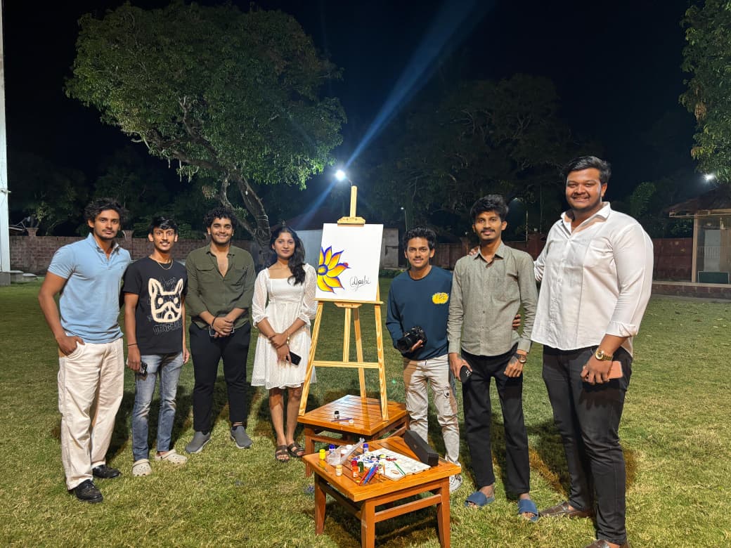Group gathered around an easel during an evening event