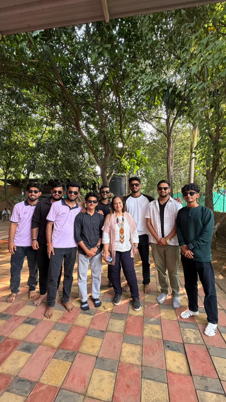 Group photographed together outdoors under trees