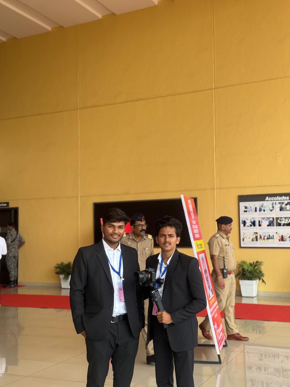 Two videographers in suits at an event venue